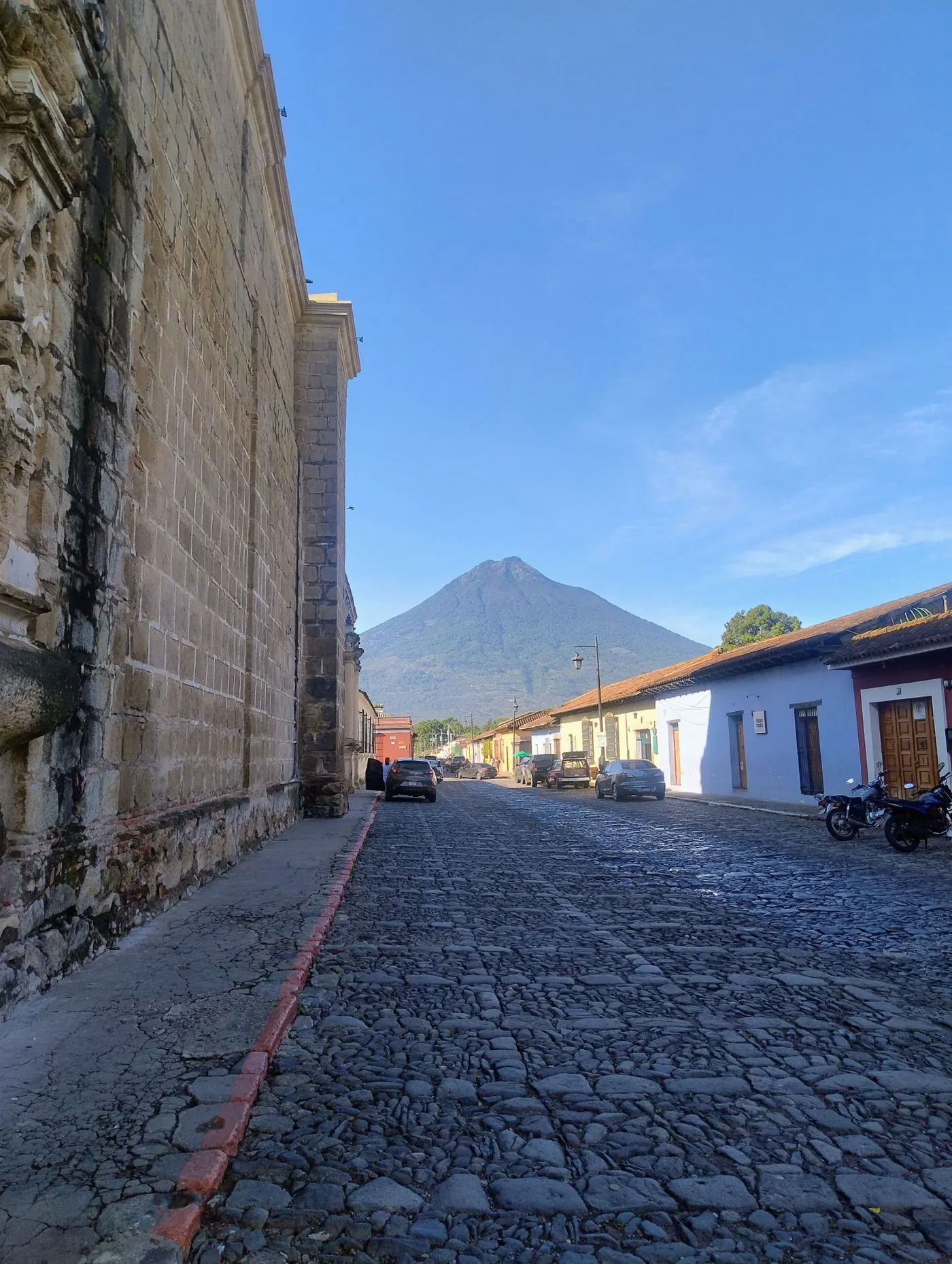 Rue pavée d'Antigua Guatemala avec le volcan de Agua à l'horizon